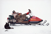 Saami reindeer herder, Johan Logje, rests with his feet up on his snowmobile handlebars. Kautokeino. North Norway. 1985