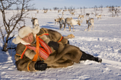 Saami reindeer herder, Nils Peder Gaup, relaxing while out keeping watch over his reindeer at their winter pastures near Kautokeino. Finnmark, North Norway. 2007