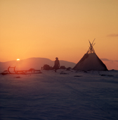 Saami woman by her Lavo (tent) at sunset. Spring Migration. Finmarksviida. North Norway. 1972