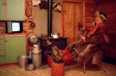 Saami herder warms up by his stove after a day's work. Baddasjokha, Finnmark, Norway. 1990