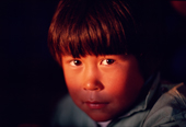 A shaft of autumn sunlight catches Qaavigarsuaq Danielsen's face,an Inuit boy from Northwest Greenland. 1987