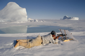 Concealed behind a white linen screen Inuit hunter, Jeremias Petersen, shoots a seal.Savissivik, NW.Greenland. 1997