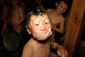 A Nenets boy at the boarding school in Panaevsk washes his face in a Russian bath. Yamal. W.Siberia, Russia.