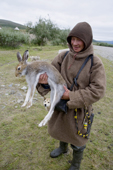 Khanty reindeer herder, Andrei Kondigen, holds an arctic hare that his dog caught. Polar Ural Mountains, Yamal, W.Siberia, Russia