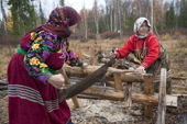 Vera & Irina Purgurchina, two Khanty women, sawing firewood outside their home on the bank of the Synya River. Yamal, Western Siberia, Russia