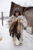 Yalena, an elderly Selkup woman holds sable skins caught by her husband at their winter camp in the forest. Krasnoselkup, Yamal, Western Siberia, Russia. (2012)
