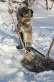 Gennadiy Kubolev, using a traditional Selkup shovel to remove pieces of ice from the water while checking a fishing net in a frozen River. Krasnoselkup, Yamal, Western Siberia, Russia. (2012)