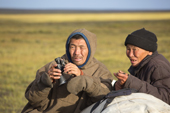 Slava Oktetto (left)and Andre Khudi, Nenets reindeer herders, keep watch over the reindeer at their summer pastures on the tundra. Yamal Peninsula, NW Siberia, Russia
